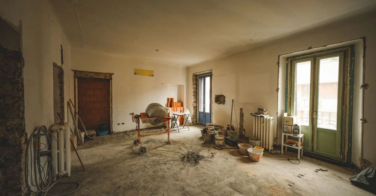 Vue d'ensemble d'une pièce ensoleillée en rénovation avec des matériaux et outils de construction, idéale pour des concepts d'amélioration de l'habitat.