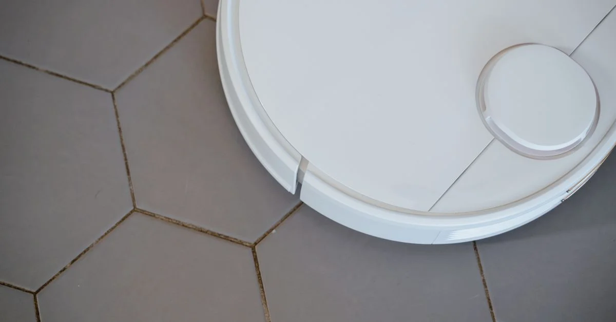 Gros plan sur un aspirateur robot sur des carreaux hexagonaux pour un nettoyage efficace.