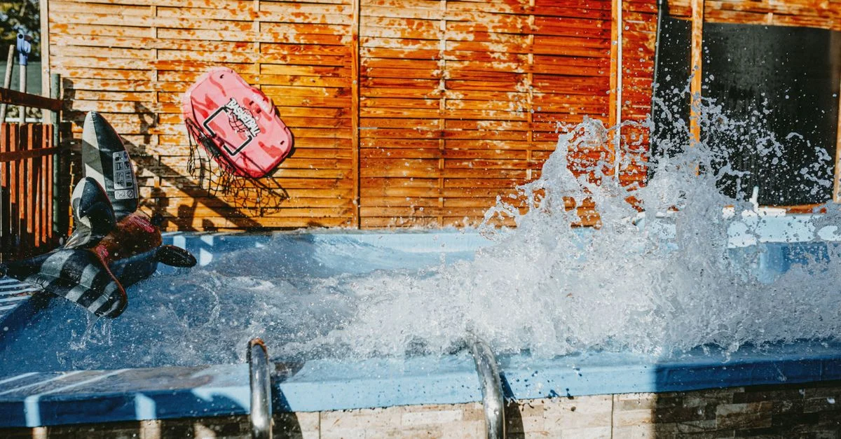Des plongeons excitants dans une piscine par une journée ensoleillée avec des structures gonflables, capturant la joie de l'été en plein air.