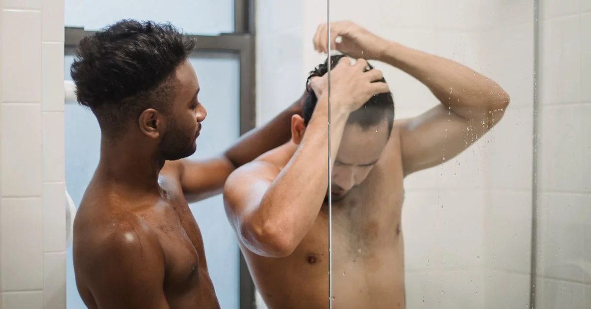 Un moment tendre entre deux hommes sous la douche, mettant en avant l'intimité et la romance.