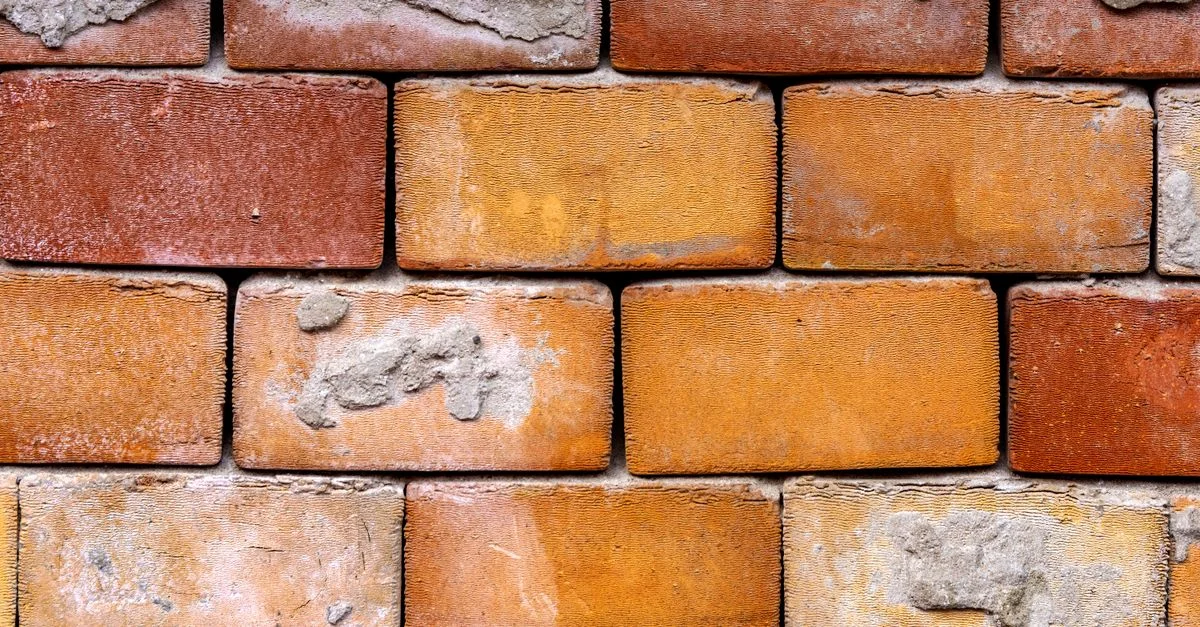 Gros plan détaillé d'un mur en briques vieilli, mettant en valeur la texture et le motif de construction.