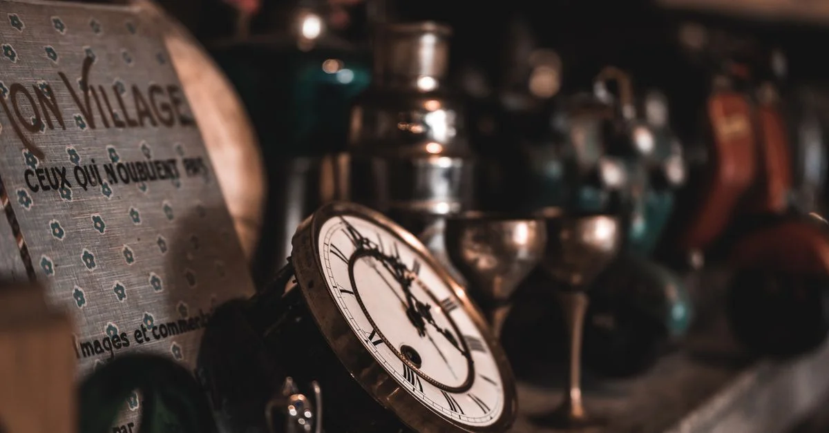 Un gros plan d'horloges vintage et d'objets anciens sur une étagère, créant une ambiance nostalgique.
