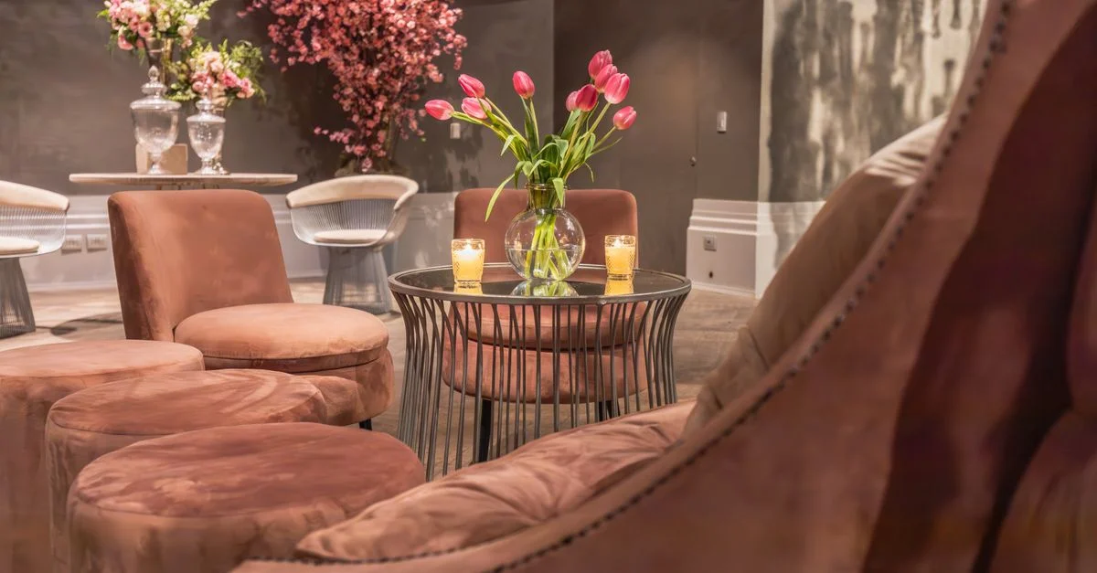 Salon moderne avec mobilier élégant et arrangements floraux vibrants créant une ambiance sophistiquée.