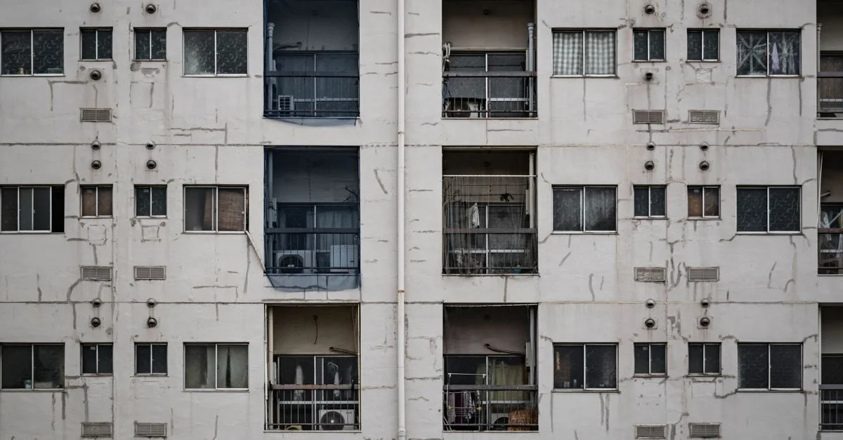 Gros plan sur la façade délabrée d'un immeuble d'appartements à Osaka, mettant en valeur l'architecture urbaine.