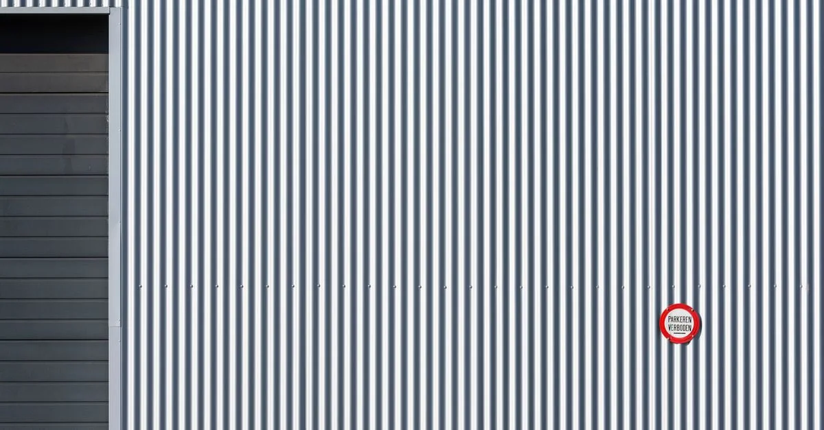 Un mur industriel rayé avec un panneau d'interdiction, offrant des lignes graphiques fortes.